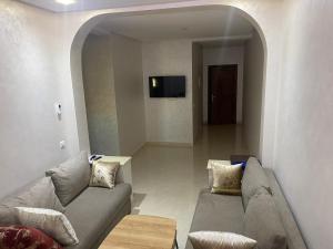ein Wohnzimmer mit einem Sofa und einem TV in der Unterkunft Jada Gzenaya in Tangier