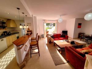 a kitchen and a living room with red furniture at Portmán Chillout in Portman