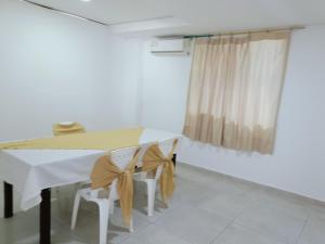 Fonseca的住宿－Hotel Mayte，一间配备有白色桌椅的用餐室