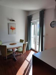 ein Esszimmer mit einem Tisch, Stühlen und einem Fenster in der Unterkunft Apartmani Seka in Vodice