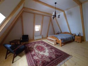 1 dormitorio con cama, mesa y alfombra en Casa Valea Vinului-traditional house in Maramureș, en Vişeu de Sus