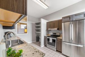una cocina con armarios de madera y electrodomésticos de acero inoxidable en Modern Condo Inside The Historic St Regis, en Grand Junction