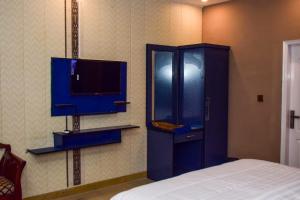 a bedroom with a blue cabinet and a tv at The Royal Sea Clifton in Karachi