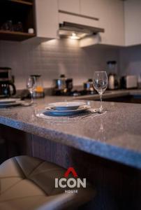 two wine glasses and a plate on a kitchen counter at Elegant 1BR in San Isidro / Pool in Lima