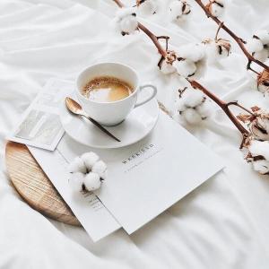 una taza de café sentada en un plato junto a un libro en Thessaloniki Harmony Life apartment, en Tesalónica