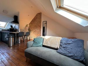 uma sala de estar com um sofá e uma cozinha em IMMEUBLE ST-PIERRE - GARE 10min - HORTILLONNAGES 5min - WIFI - TV HD em Amiens
