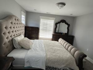 a bedroom with a large bed and a mirror at Modern Luxury Apartment near GRR Airport and Mall in Kentwood