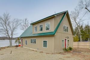uma casa com um telhado verde em cima em Lakefront Bucksport Home with Fire Pit and Gas Grill! em Bucksport