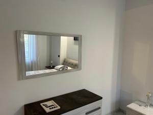 uno specchio su una parete bianca sopra un lavandino di Appartamento con Terrazzo a Mariglianella