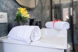 two rolls of towels sitting on a counter in a bathroom at TIMEO central apartment in historic sicilian baroque-style building in Catania +83 photos