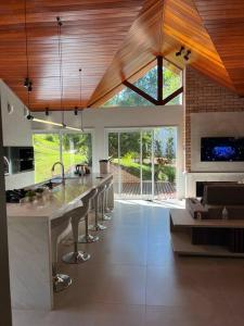 a kitchen with a large island with bar stools at Casa de Campo - Rancho dos Lagos in Cascavel