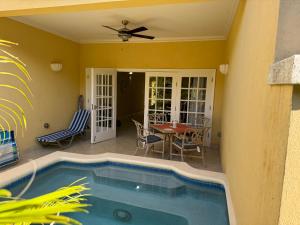 a patio with a swimming pool and a table and chairs at Westland villa's in Saint James