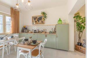 uma cozinha com armários verdes e uma mesa e cadeiras em Fly B&B em Pisa