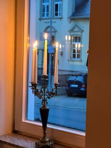 einem Kerzenhalter vor einem Fenster mit einem Auto in der Unterkunft Exklusive 2 Zimmerwohnung im nostalgischen Stil nahe der Limburger Altstadt in Limburg an der Lahn