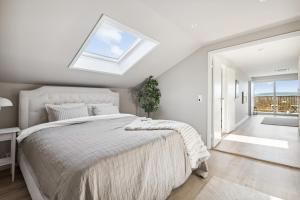 a bedroom with a large bed with a skylight at Luxury house with 5 bedrooms close to Oslo Centrum in Lorenskog