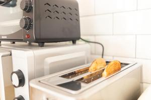 a toaster oven with two pieces of bread in it at Fly B&B in Pisa