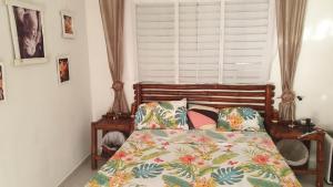a bed in a bedroom with a window and a bedspread at Meridiana in Las Terrenas