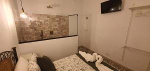 Dormitorio pequeño con cama y TV en La Morería y su jacuzzi, en La Puebla de los Infantes