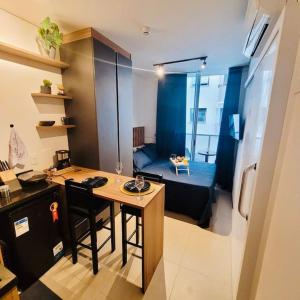 een klein appartement met een bureau en een kamer met een bed bij Studio moderno próx a av Paulista in Sao Paulo