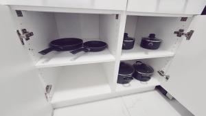 a kitchen with white shelves with pots and pans at 3bed 1 bath suite - Surrey Fleetwood in Surrey