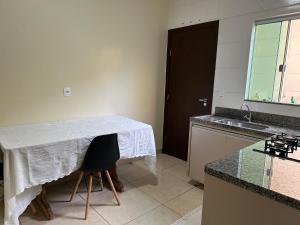 uma cozinha com uma mesa com uma toalha de mesa branca em Apartamento aconchegante em Rio Verde