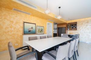 une salle à manger avec une table et des chaises blanches dans l'établissement Apartment Laurus five stars, à Dubrovnik