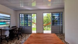a bedroom with a bed and a table and windows at Vivienda Rural La Estancia in Duitama