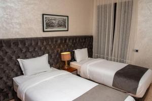 Habitación de hotel con 2 camas y ventana en Marrakech Only For Families 2BR - Fun Pool, en Marrakech