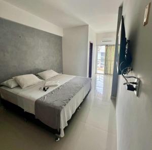 una camera da letto con un letto e una TV a parete di Hotel New Tokyo a Capitão Poço