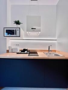 a kitchen with a sink and a microwave at Sorolla Urban Suites in Valencia +9 photos