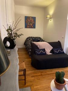 una sala de estar con un sofá negro en una habitación en Le Jean Jaurès en Troyes