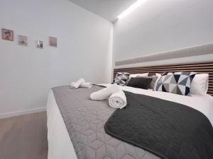 a bedroom with a large bed with towels on it at Sorolla Urban Suites in Valencia