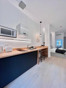 eine Küche mit einer Theke mit einer Spüle und einer Mikrowelle in der Unterkunft Sorolla Urban Suites in Valencia