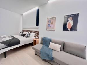 um quarto com duas camas e um sofá em Sorolla Urban Suites em Valência