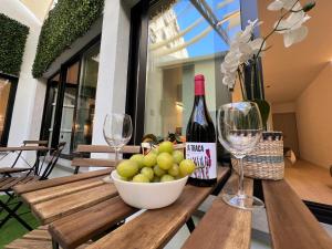 a table with a bowl of grapes and wine glasses at Sorolla Urban Suites in Valencia