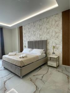 拿坡里的住宿－Napoli Central Suites，一间卧室设有一张床和大理石墙
