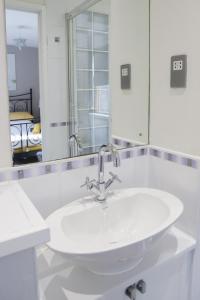a white bathroom with a sink and a mirror at Number1Townhouse with private balcony & Parking in Glasgow