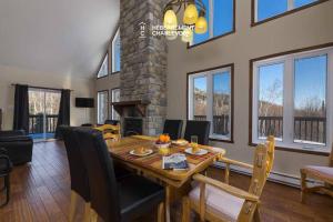 a dining room and living room with a table and chairs at Au chalereux chalet Petite-rivière-saint-françois in Petite-Rivière-Saint-François