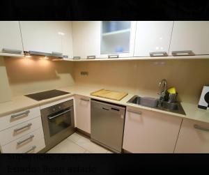 a kitchen with white cabinets and a sink at Apartament Calella in Calella