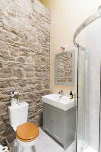 a bathroom with a toilet and a sink at Stunning Granite Barn Conversion in Tullow