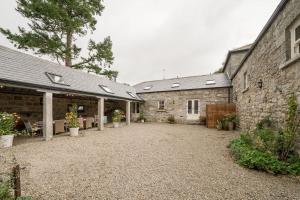 a courtyard of a house with two buildings at Stunning Granite Barn Conversion in Tullow