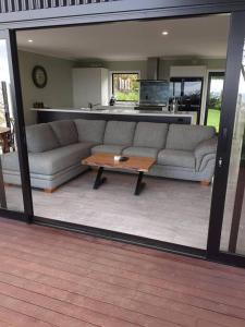 a living room with a couch and a coffee table at Golden Bay Heights - Luxury Accommodation in Parapara 