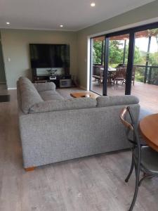 ein Wohnzimmer mit einem Sofa und einem Tisch in der Unterkunft Golden Bay Heights - Luxury Accommodation in Parapara 