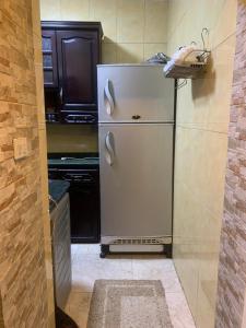 een keuken met een witte koelkast in de kamer bij Bienvenidodepartamento in Caïro