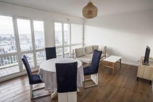 sala de estar con mesa, sillas y sofá en Charming 63 m2 apt with views of the Eiffel Tower, en LʼÎle-Saint-Denis