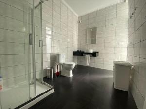 a bathroom with two toilets and a glass shower at White Pico Lodge in São Roque do Pico