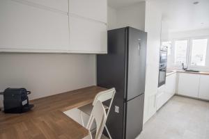 cocina con mesa y nevera en Charming 63 m2 apt with views of the Eiffel Tower, en LʼÎle-Saint-Denis