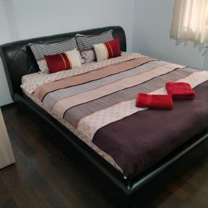 un grande letto con due cuscini rossi sopra di Studio Old Center a Braşov