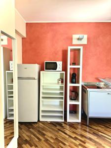 a kitchen with a white refrigerator and a microwave at San Filippo Studio Biella Centro in Biella