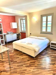 a bedroom with a large white bed and a kitchen at San Filippo Studio Biella Centro in Biella